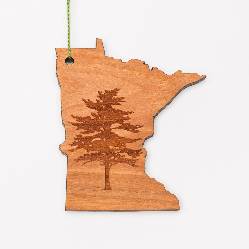 Pine tree laser etched into a Minnesota-shaped wood ornament